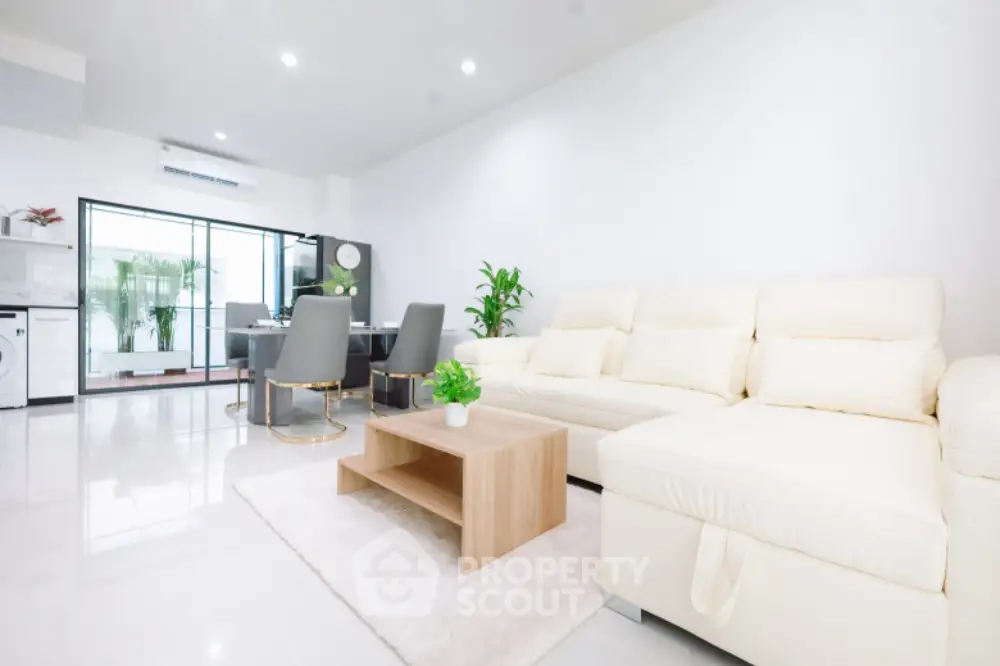 Spacious modern living room with elegant white sofa and dining area
