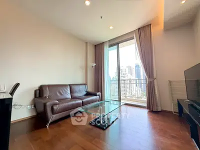 Spacious living room with modern furniture and city view balcony in high-rise apartment.