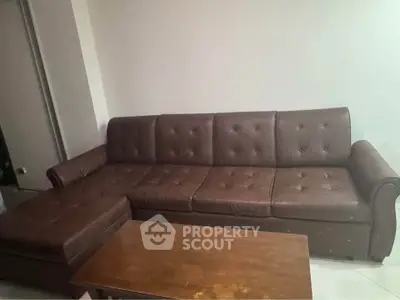 Spacious living room with elegant brown leather sofa and wooden coffee table.
