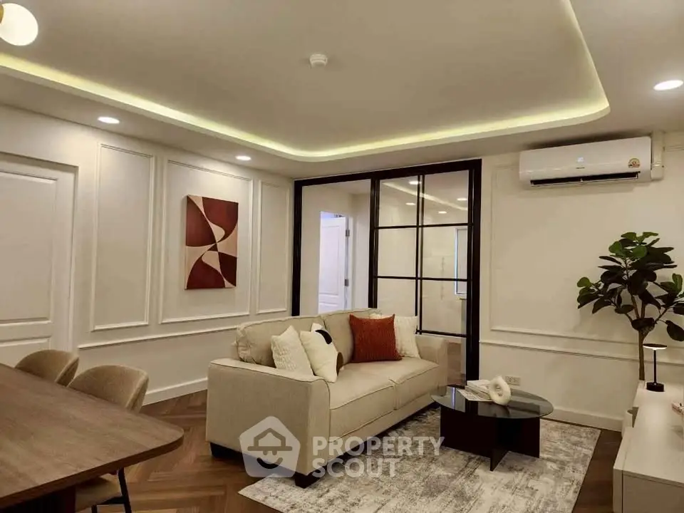Modern living room with elegant decor and stylish furniture, featuring a cozy sofa and chic lighting.