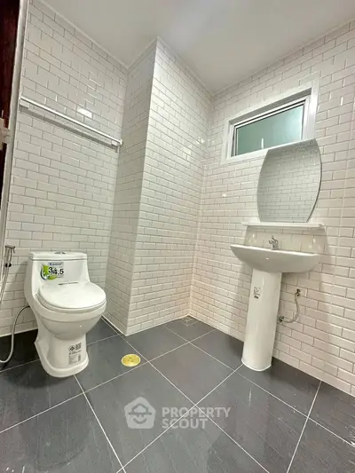 Modern bathroom with sleek white tiles and contemporary fixtures.