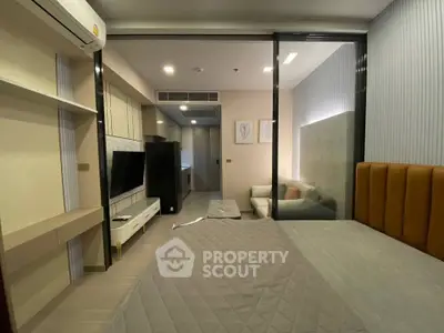 Modern studio apartment with sleek design, featuring a cozy bed, stylish living area, and efficient kitchen layout.