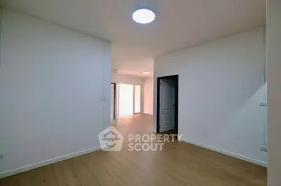 Spacious empty room with wooden flooring and bright natural light
