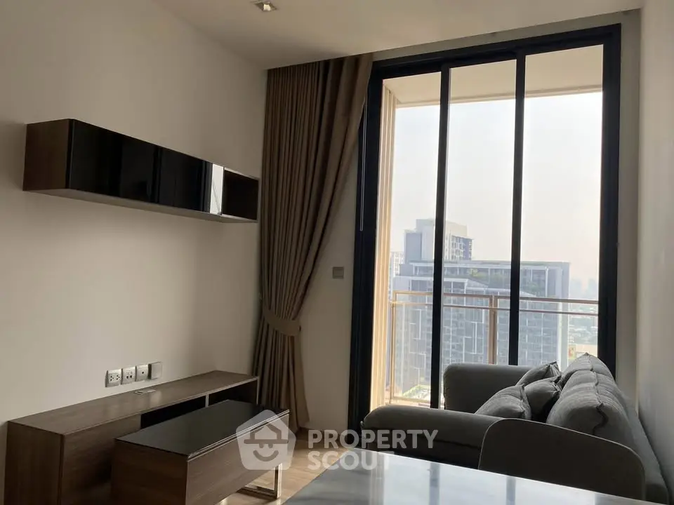 Modern living room with large windows and city view, featuring sleek furniture and elegant design.
