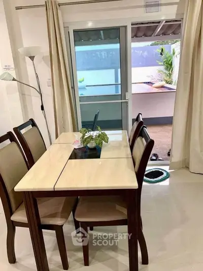 Charming dining area with elegant table and chairs, leading to a cozy balcony with outdoor seating.