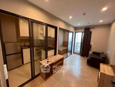 Modern apartment with open layout, featuring a cozy living area and balcony access.