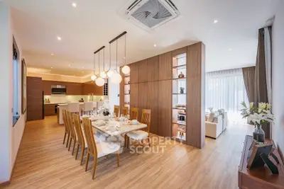 Spacious open-plan dining and living area with modern wooden accents and elegant lighting.