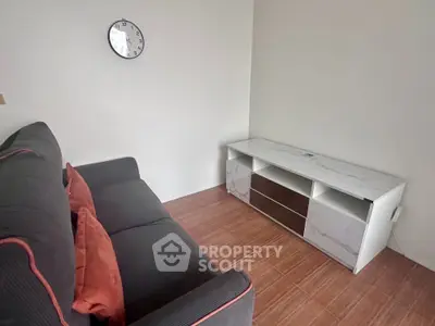 Cozy living room with modern sofa and sleek TV stand, perfect for relaxation.