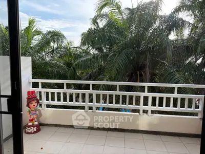 Spacious balcony with lush palm tree views, perfect for relaxation and enjoying nature.