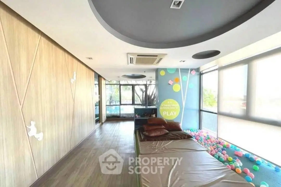 Spacious modern living room with large windows and stylish ceiling design.