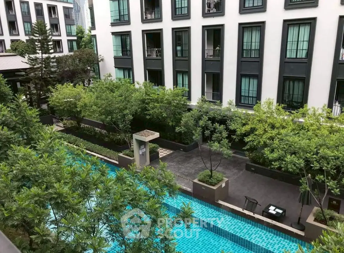 Modern apartment building with lush garden and inviting swimming pool view.