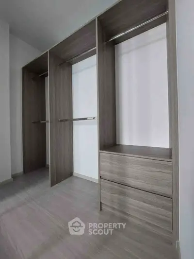Spacious walk-in closet with modern wooden shelving and drawers, perfect for organized storage.