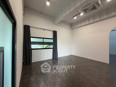 Spacious modern room with high ceiling and large window