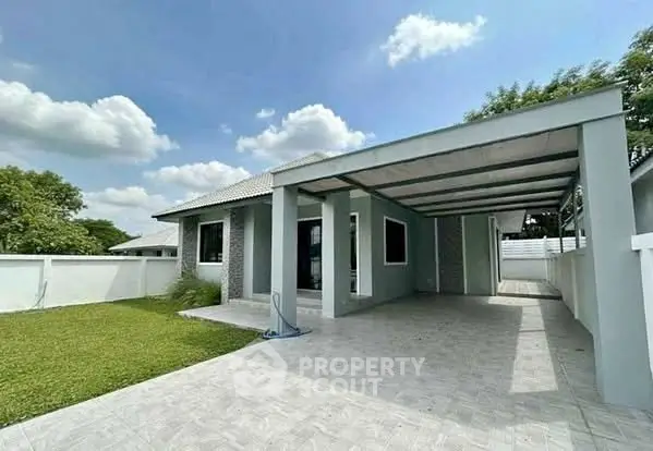 Modern single-story house with spacious carport and lush green lawn.