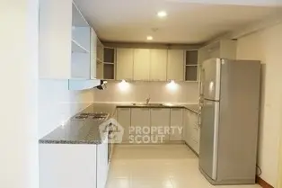 Modern kitchen with sleek cabinetry and stainless steel fridge in a spacious layout.
