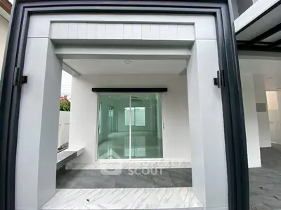 Modern home entrance with sleek sliding glass doors and stylish exterior design.