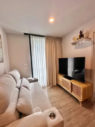 Cozy living room with modern sofa and large TV, perfect for relaxation.