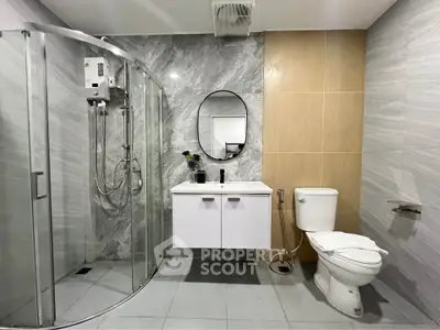Modern bathroom with sleek shower and elegant vanity in stylish apartment.
