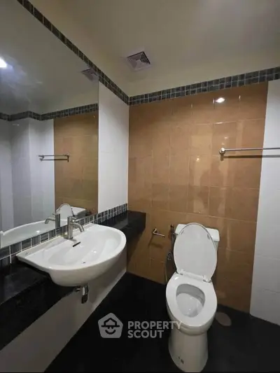 Modern bathroom with sleek fixtures and neutral tiles, perfect for a contemporary home.