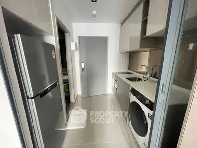 Modern kitchen with sleek appliances and washing machine in compact layout