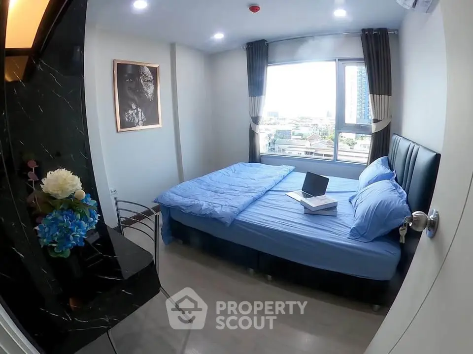 Modern bedroom with city view, featuring a cozy bed and stylish decor, perfect for urban living.