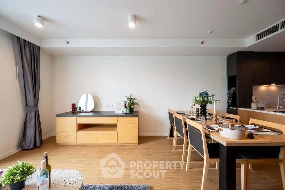 Modern open-plan living and dining area with stylish decor and wooden flooring.