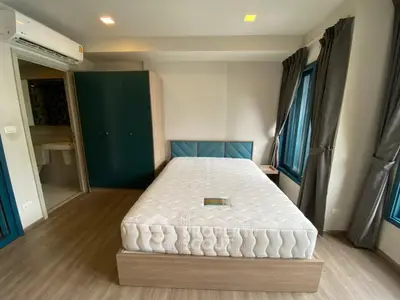 Modern bedroom with stylish decor and natural light, featuring a comfortable bed and elegant furnishings.