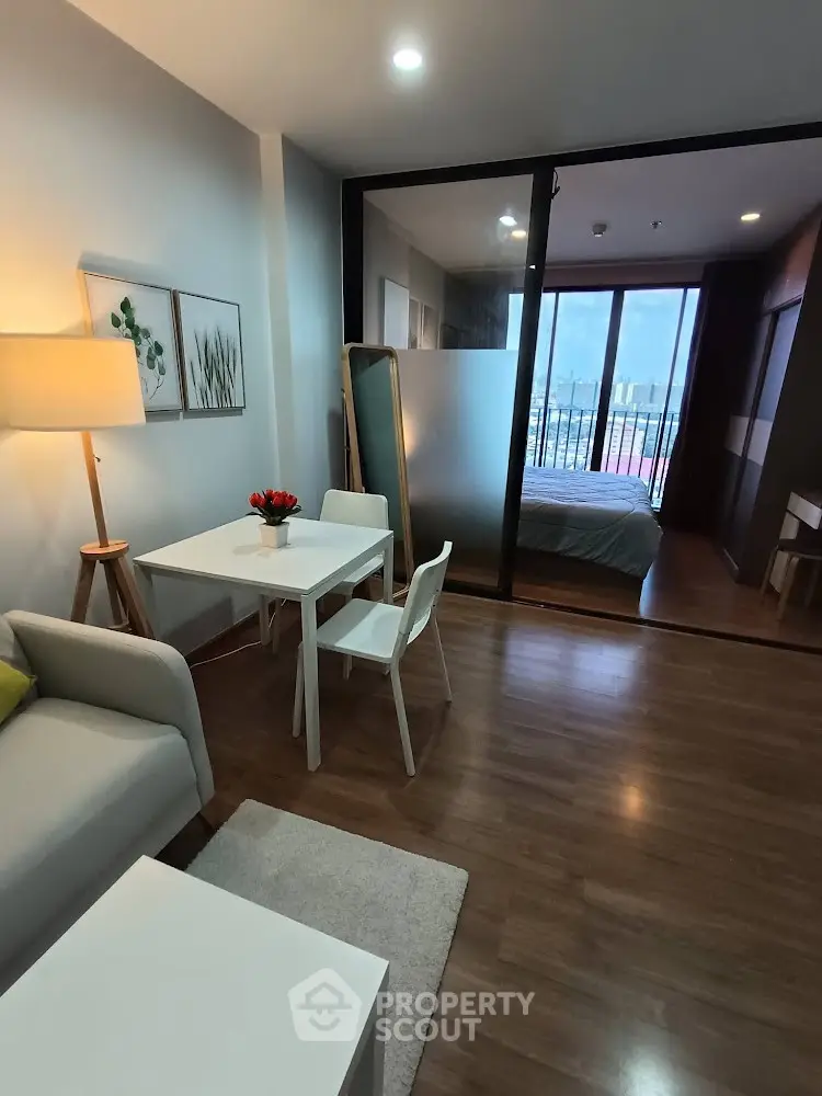 Modern open-plan living room with dining area and bedroom view