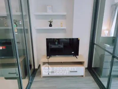 Modern living room with sleek TV stand and glass partitions, perfect for urban living.