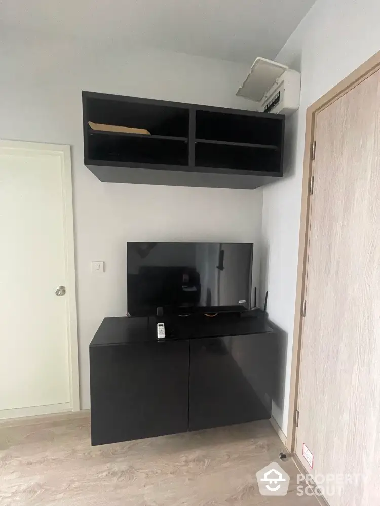 Modern living room with sleek black TV cabinet and wall-mounted storage