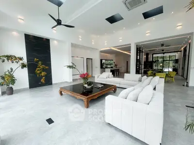 Spacious modern living room with elegant decor and open layout, featuring stylish furniture and abundant natural light.