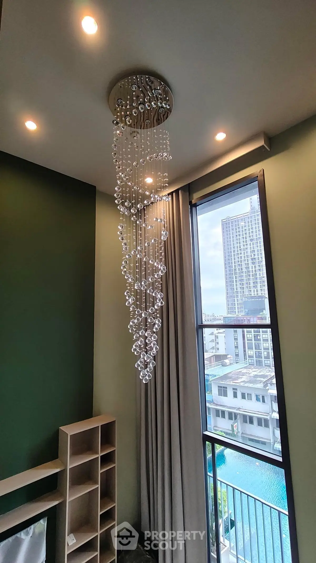 Luxurious modern interior with elegant chandelier and city view, perfect for urban living.