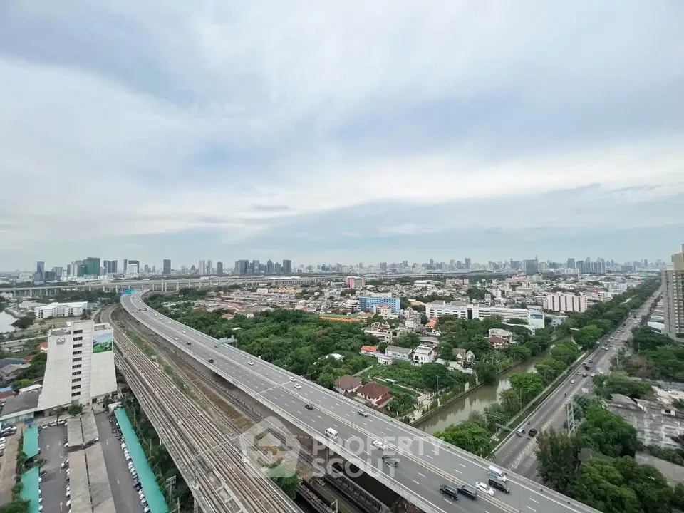 Stunning cityscape view from high-rise building overlooking highways and urban skyline.