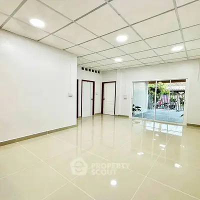 Spacious and bright interior with glossy tiled floors and sliding glass doors.