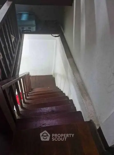 Narrow wooden staircase leading to a lower level in a residential property.