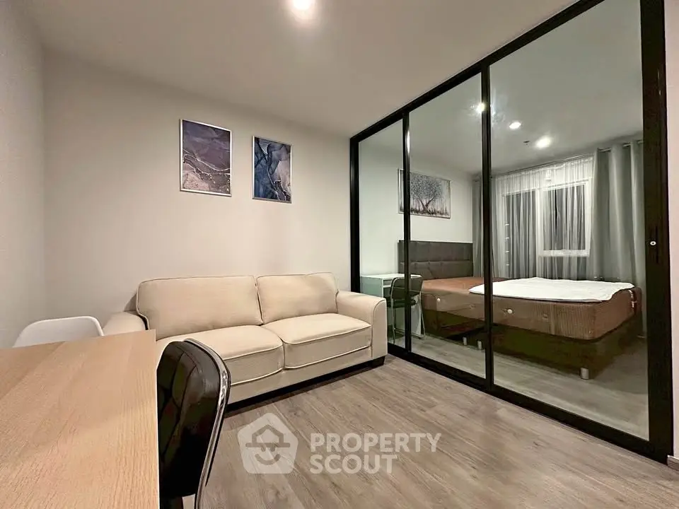 Modern studio apartment with glass partition, cozy living area, and stylish decor.