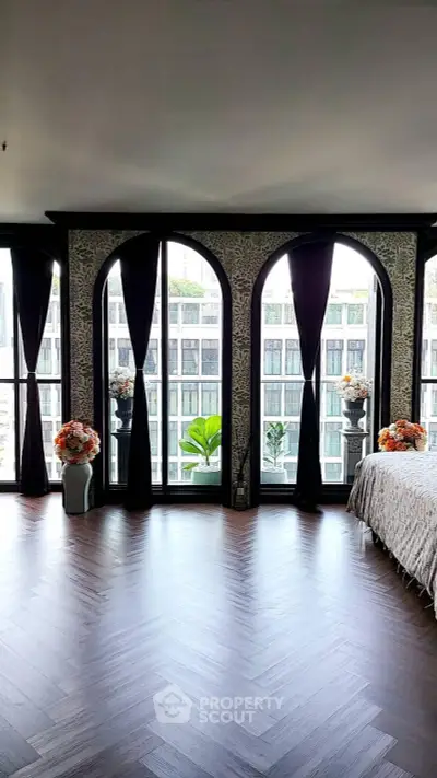 Luxurious bedroom with elegant arched windows and stunning city view