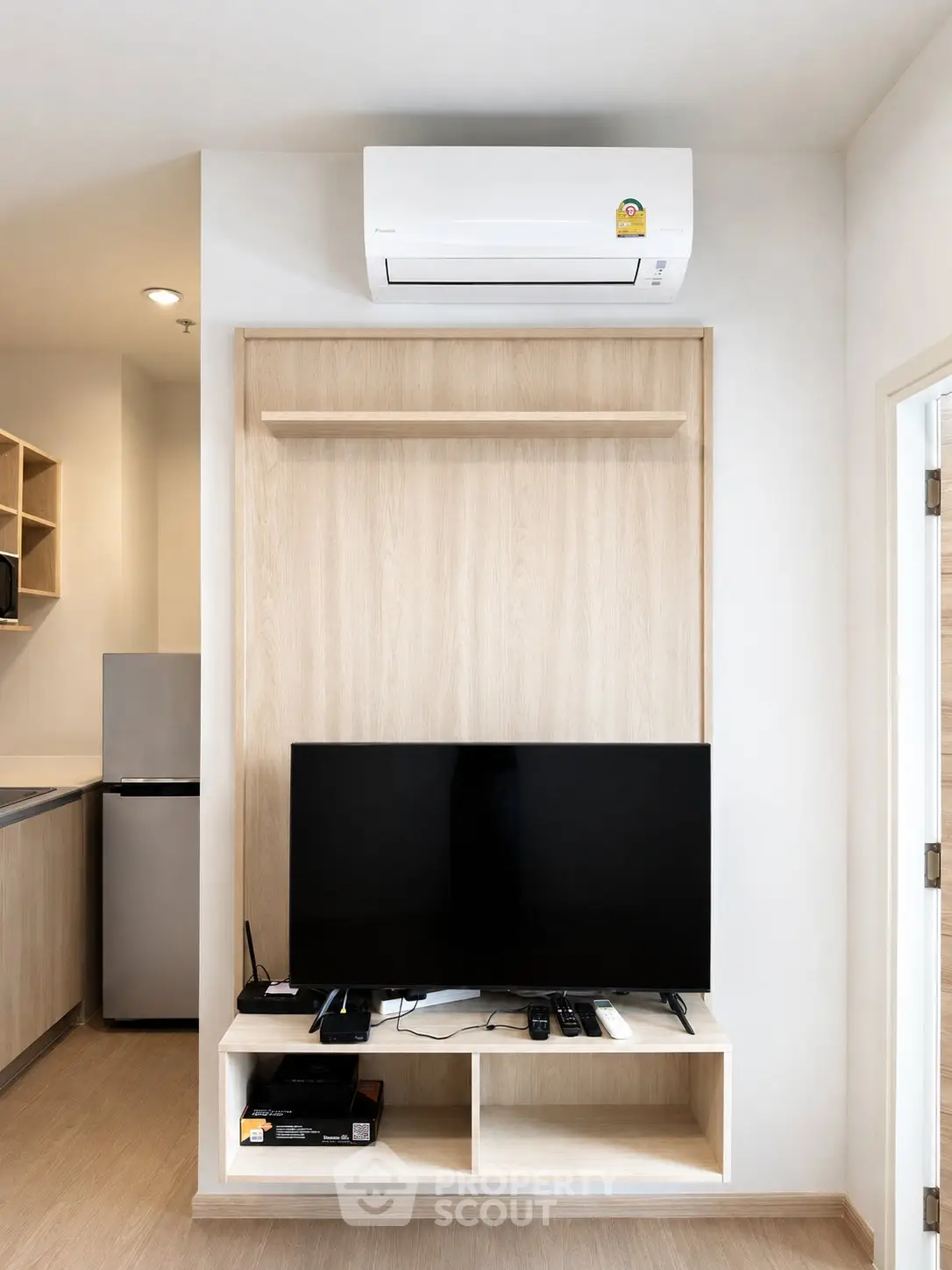 Modern living room with sleek TV setup and air conditioning in stylish apartment.