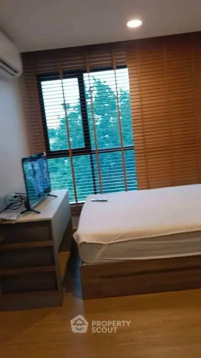 Cozy bedroom with wooden blinds and modern furnishings, perfect for relaxation.