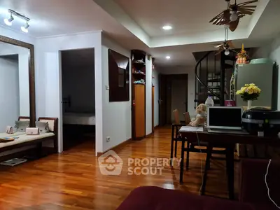 Charming open-plan living space with spiral staircase and warm wooden flooring