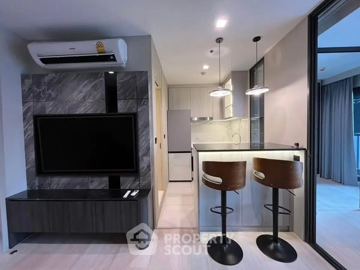 Modern living room with sleek TV setup and stylish kitchen bar area