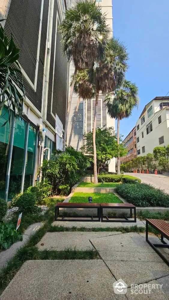 Modern building exterior with lush landscaping and tall palm trees