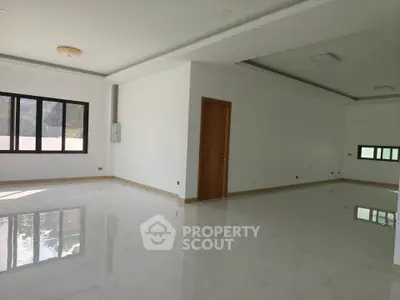 Spacious modern living room with elegant flooring and large windows for natural light.