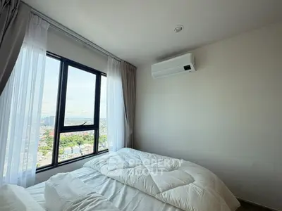 Bright bedroom with large window offering stunning city view and modern air conditioning unit.