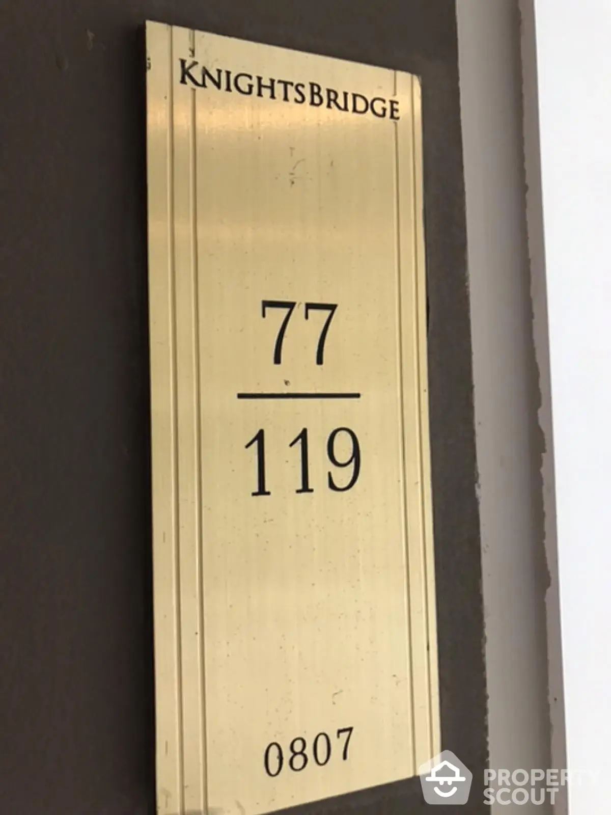 Elegant Knightsbridge building plaque with unit numbers 77 and 119, showcasing luxury real estate.