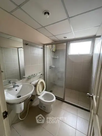 Modern bathroom with glass shower and sleek fixtures in a contemporary apartment.