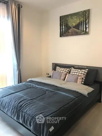 Modern bedroom with stylish decor and natural light, featuring a cozy bed and elegant curtains.