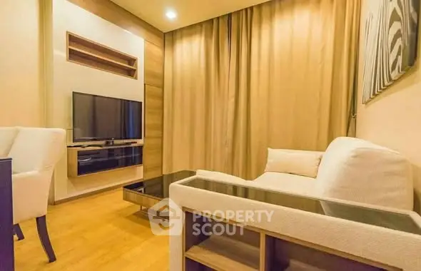 Modern living room with cozy seating and wall-mounted TV in stylish apartment.