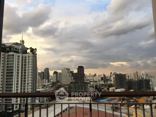 Stunning cityscape view from a high-rise balcony, showcasing urban skyline and dramatic clouds.