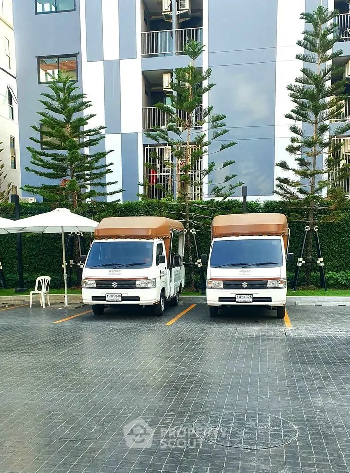 Modern apartment building with parking area and two parked vehicles